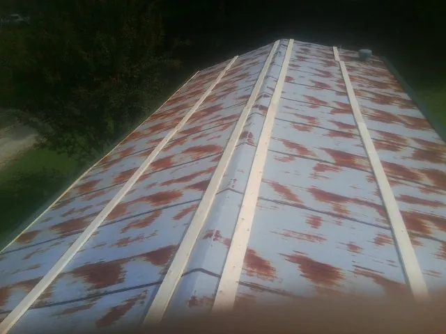 Rusted metal roof panels with new wood purlins before replacement — Storm Damage Roof Repair in Rehoboth Beach by Roofing Brothers